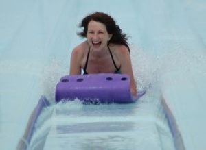 Woman Having sliding down Fun on water slide - Reducing Stress