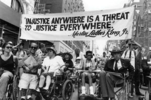 Sign held saying Injustice Anywhere is a threat to justice everywhere